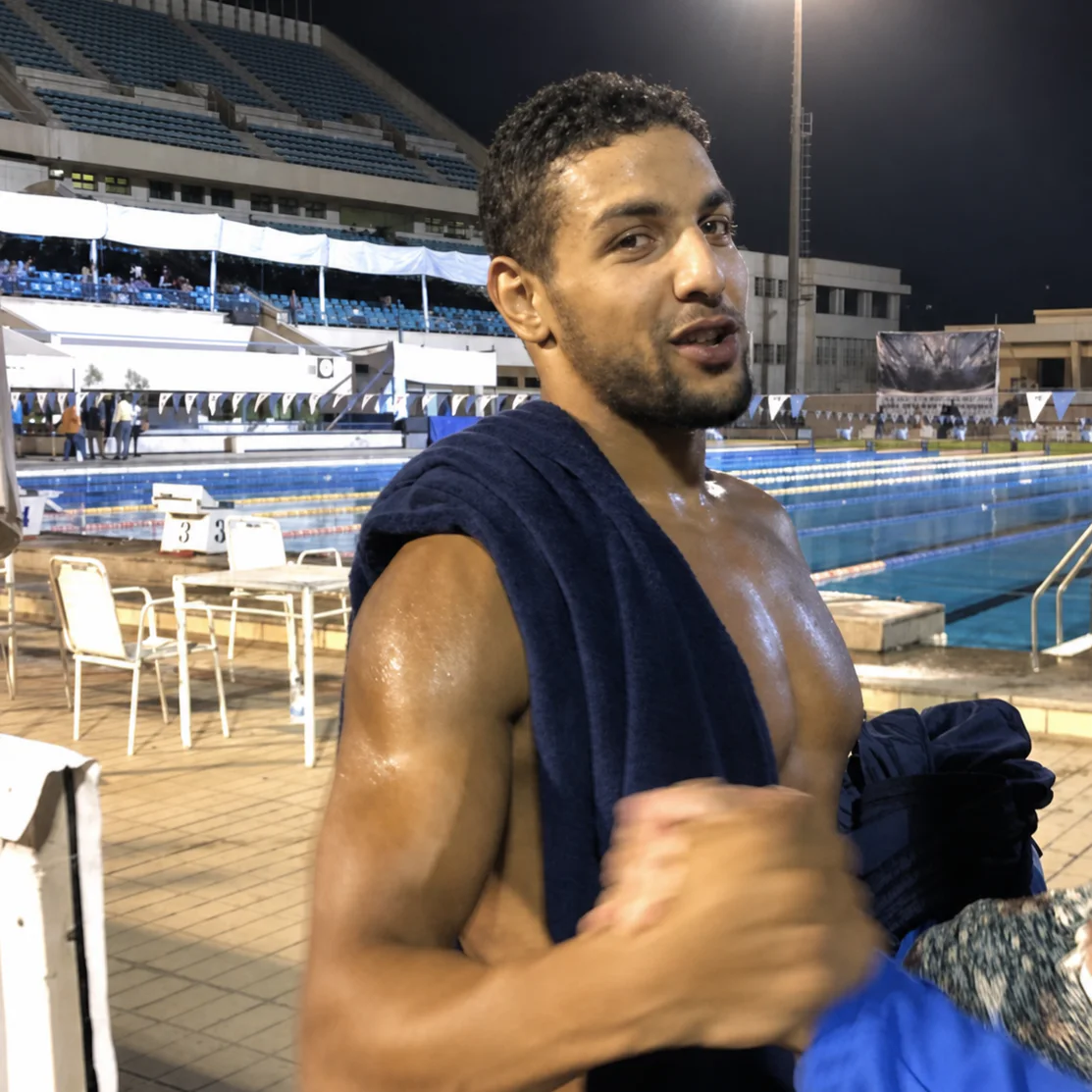 Omar Elewa on the pool deck, a towel over his shoulder