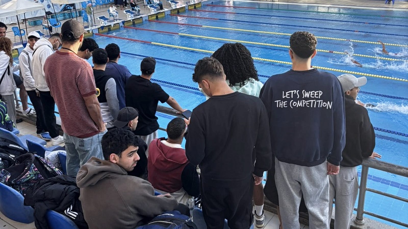 The SWEEP team at the rail, watching a teammate race on meet day