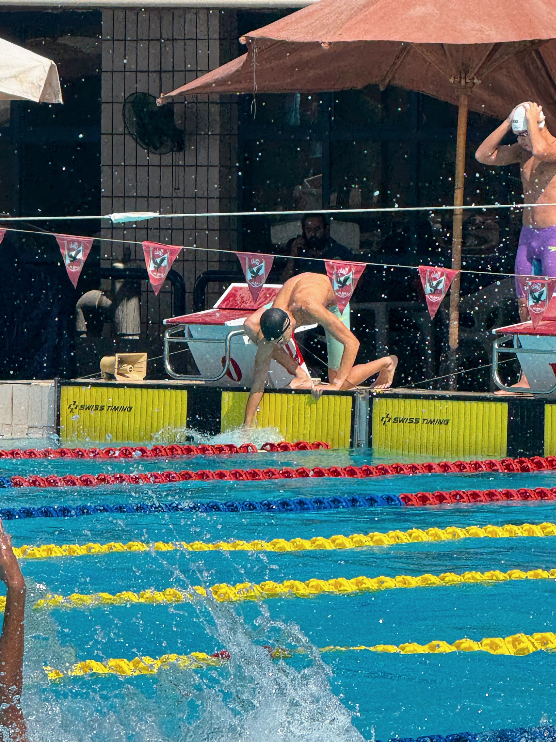 A SWEEP swimmer diving off the block, spray still in the air